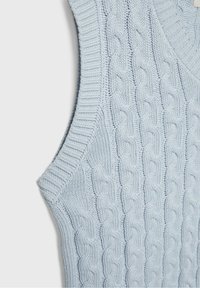 Hellblauer gestrickter Pulloverweste mit strukturiertem Zopfmuster, geripptem Kragen und Armausschnitten. Nahaufnahme der Stoffdetails.