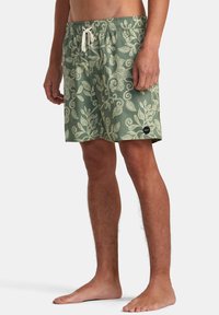 Pantaloni da bagno verdi con un motivo a foglia bianca, vita elastica con cordoncino e etichetta con logo sull'orlo. Tessuto leggero.