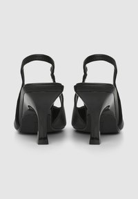 Scarpe nere con tacco alto, design a slingback, materiale sintetico liscio, punta aperta e finitura lucida sui tacchi.