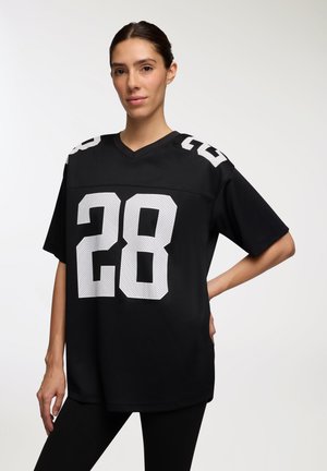 Maglia da football nera oversize con numeri in rete bianchi "28" e "77" sulle spalle. Presenta un design a girocollo e maniche rilassate.
