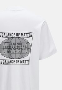 White cotton t-shirt featuring a black graphic design with text and globe illustration on the back. Short sleeves and crew neck style.
