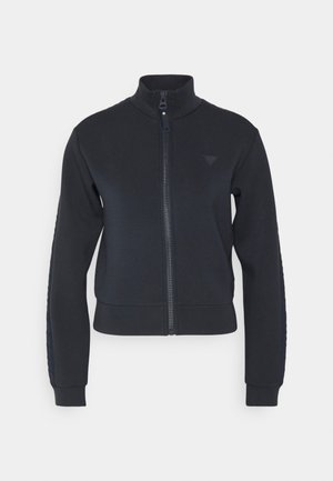 Tumesinine T-särk, millel on kõrge kaelus, ribakätised ja tekstureeritud külgpaneel. Esiküljel on väike embleem. Pehme kangas.