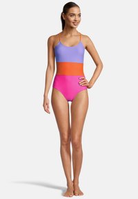 Eén stuk badpak met een paarse top, oranje middenstuk en een roze onderkant. Gemaakt van een gladde stof met dunne bandjes en hoge uitsnedes.