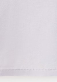 Tissu gris clair avec une texture fine visible et un ourlet droit cousu sur le bord inférieur.