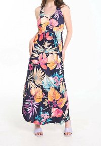 Robe longue avec un fond bleu marine foncé, ornée de grands motifs floraux colorés en rose, orange et bleu. Tissu lisse avec un col en V.