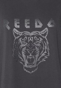 T-shirt preta com um gráfico em glitter prateado ousado da face de um tigre e a palavra "LIBERDADE" acima, apresentando uma textura suave e gola redonda.