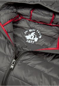Veste rembourrée avec un extérieur gris et des accents rouges, dotée d'une fermeture éclair et d'un logo intérieur avec un graphique de scooter en blanc.