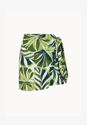 Grüner und weißer Wickelrock mit tropischem Blattmuster und Seitenschleifen-Detail vor einem einfarbigen Hintergrund.