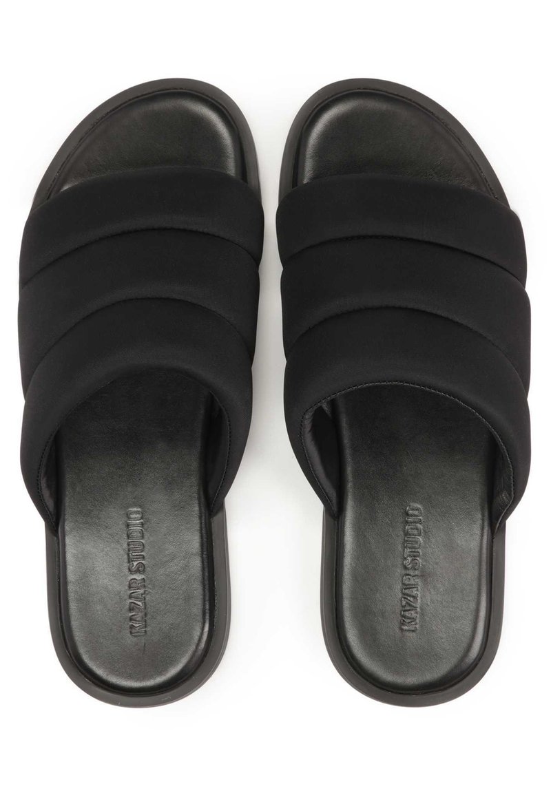 Sandales noires à glissière avec un dessus en tissu doux, présentant trois larges sangles et une semelle lisse et texturée. Design bas avec des bords arrondis.