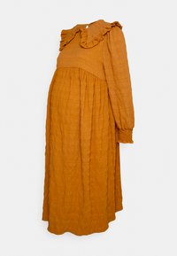 Vestido de maternidade longo, amarelo mostarda, feito de tecido texturizado. Apresenta colarinho franzido, mangas elásticas e uma silhueta solta.