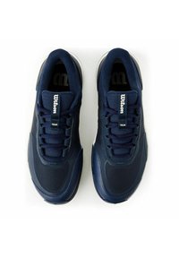 Marinblå träningsskor med en texturerad mesh-övre, vadderad krage och gummisula. Har snörning och en "Wilson"-logotyp på tungan.