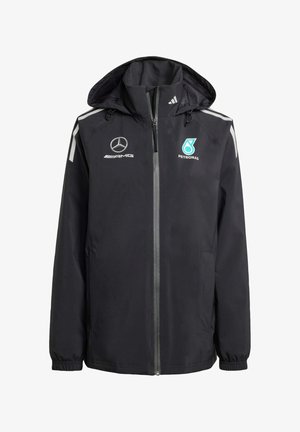 Schwarze wasserdichte Jacke mit Reißverschluss, verstellbarer Kapuze, grauen Akzenten und Logos: Mercedes AMG und Petronas. Verfügt über elastische Bündchen.
