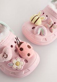 Lyserøde skumtræsko med mintgrøn bagdel, dekoreret med bløde pynteelementer: en bi, en sommerfugl, en regnbue, en mariehøne og en blomst.