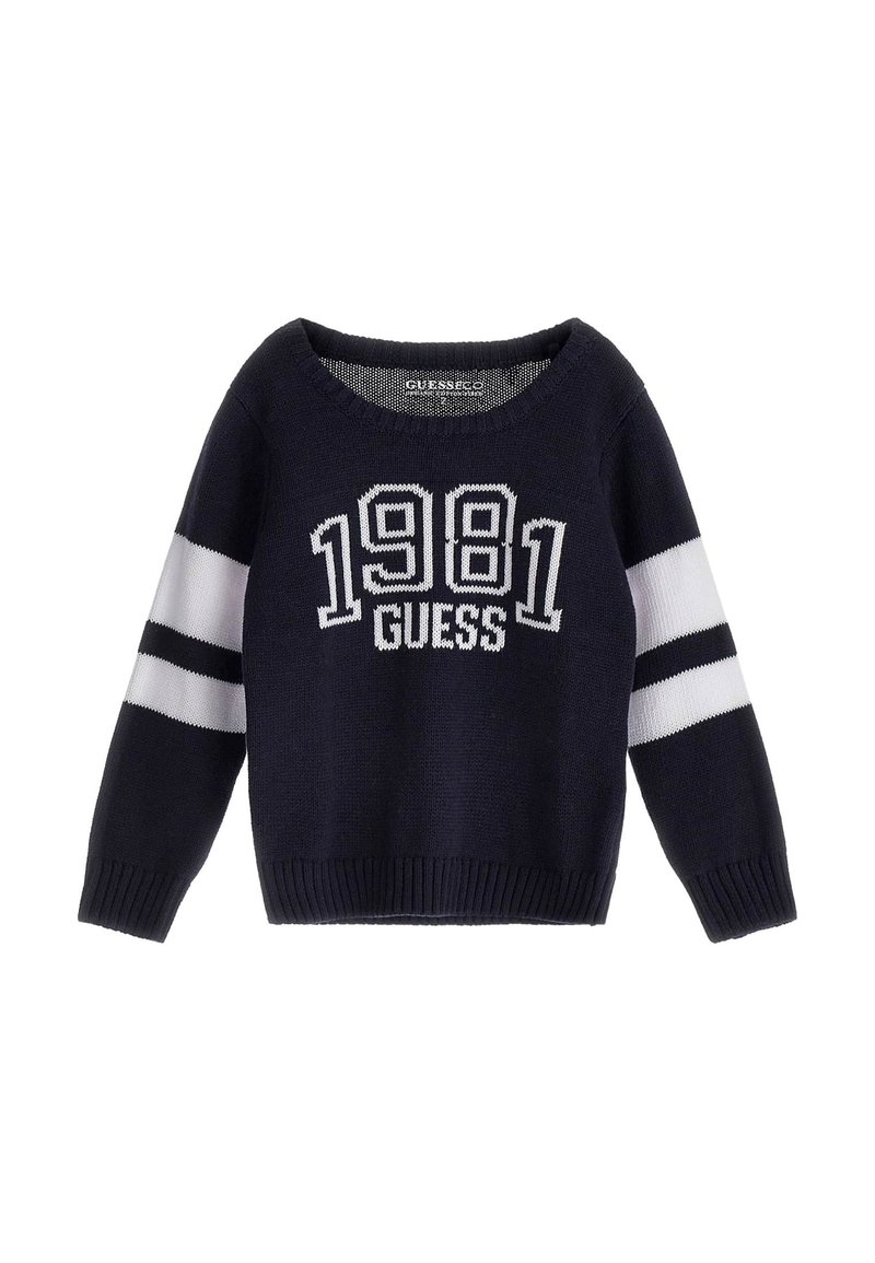 Granatowy sweter z dzianiny z białymi paskami na rękawach, z napisem "1981 GUESS" w kontrastowym białym kolorze na przodzie. Klasyczny okrągły dekolt.