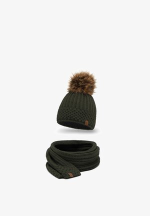 Dark green knitted beanie with a faux fur pom-pom on top and a matching textured scarf. Both feature leather brand accents.