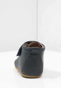 Mörkblå läderankelstövlar med ett mjukt mockaband, rundad form, sömdetaljer och en flexibel beige sula.