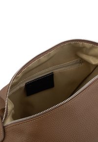 Borsa in pelle marrone con apertura superiore con zip, dotata di foderatura interna color sabbia e una tasca interna per piccoli oggetti. Superficie testurizzata con dettagli di cucitura.