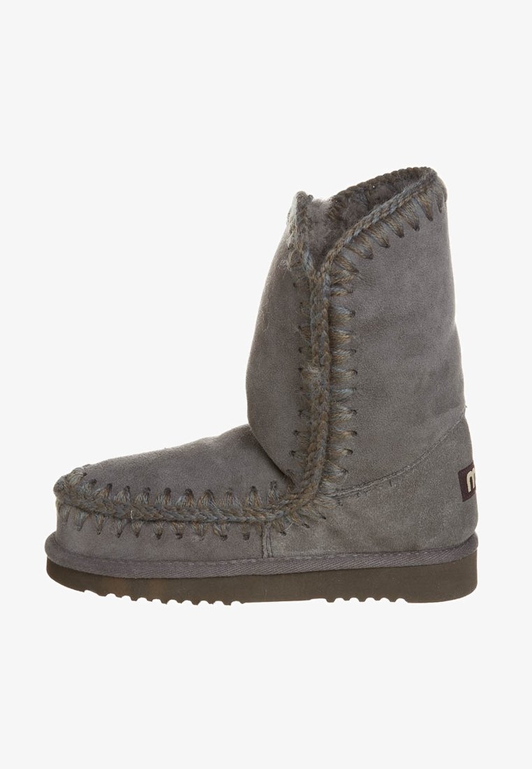 Grijze suède enkellaars met stikdetails, ronde neus en rubberen zool. Zachte textuur en gevouwen kraag zorgen voor comfort.