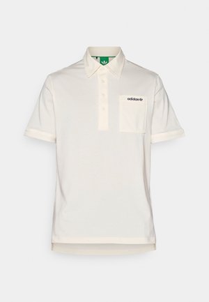 Polo krekls of-white kokvilnā ar pogāmīšu apkakli, īsām piedurknēm, krūšu kabatu un melnu logotipa akcentu kreisajā pusē.