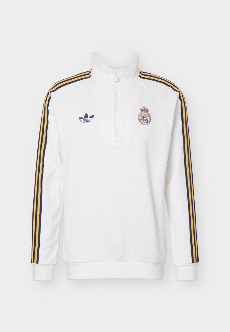 Pull-over de sport blanc à manches longues avec fermeture éclair partielle, bandes épaules bleu marine et or, logos Adidas et Real Madrid sur la poitrine.