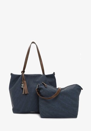 Borsa tote in tessuto blu navy con manici in pelle marrone e un pon-pon, abbinata a una borsa più piccola con tracolla coordinata.