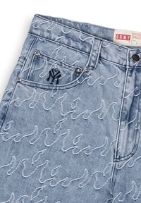 Los jeans de mezclilla azul claro presentan un patrón de ondas cosido en blanco, un bolsillo frontal con un logo negro de NY y detalles de hardware plateados.