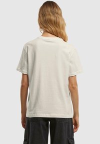 Light beige cotton t-shirt with a relaxed fit, short sleeves, and a round neckline. No visible patterns or graphics.