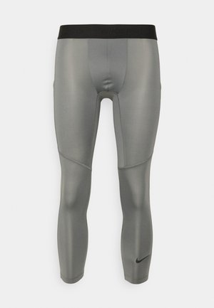 Hallid Nike Pro kompressioonipingutused hallid, millel on must elastne vöökoht. Kangas on sileda ja läikiva tekstuuriga ning sellel on lameste õmblused.
