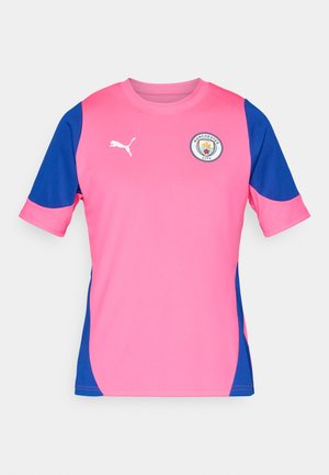 Puma Manchester City majica v svetlo roza barvi z modrimi detajli, kratkimi rokavi, okroglim ovratnikom in klubskim logotipom na prsih. Gladka tekstura tkanine.