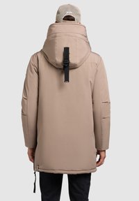 Chaqueta acolchada beige con un alto cuello y capucha, correa ajustable en la parte trasera, puños elásticos y bolsillos laterales. Tejido suave y cálido.