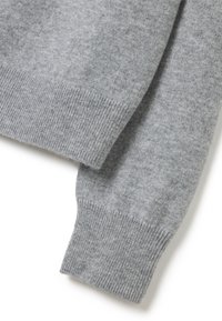 Pull en laine gris présentant un poignet et un ourlet côtelés. Le tissu a une texture douce avec un motif chiné subtil.
