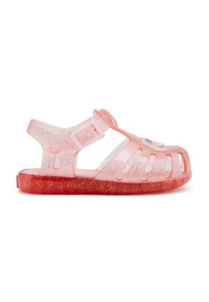 Sandal de gelatina translúcida rosa con suela roja brillante. Presenta recortes, correa ajustable y un acento colorido en la punta.