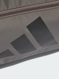 Borsa sportiva in tessuto grigio con grande logo nero, superficie strutturata e dettagli traforati nella parte inferiore. Chiusura con cerniera nella parte superiore.