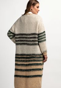 Przesadzony sweter z wełny z kremowymi, zielonymi i brązowymi paskami. Teksturowany materiał o luźnym kroju, długie rękawy i otwarty przód.