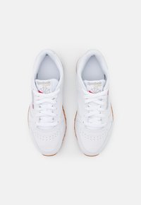 Baskets en cuir blanc avec des perforations, lacets blancs plats et semelle en caoutchouc gomme. Présente le logo Reebok sur la languette et les côtés.