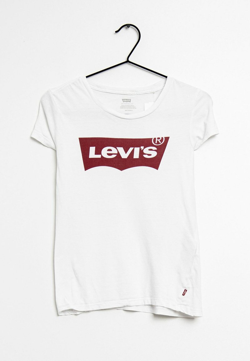 Vit bomulls-T-shirt hängande på en svart galge, med en stor vinröd Levi's-logotyp i en böjd design över bröstet.