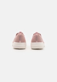 Zapatillas de malla rosa con una suela de goma blanca, que cuentan con una lengüeta y un branding sutil en el talón. Textura suave y forma redondeada.