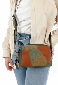 Meer kleurige leren schoudertas met patchwork ontwerp in bruin, groen en kaki. Gladde textuur met zilverkleurige metalen accenten.