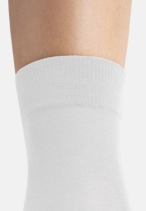 Weißer Baumwollknöchelsocke mit geripptem Bündchen, die eine glatte Oberfläche ohne auffällige Muster oder Verzierungen aufweist.