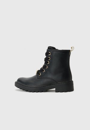 Schwarze Leder-Ankle-Boots mit goldenen Ösen, Schnürdesign, runder Zehenform und robustem Profil, ausgestattet mit einer Zuglasche an der Rückseite.