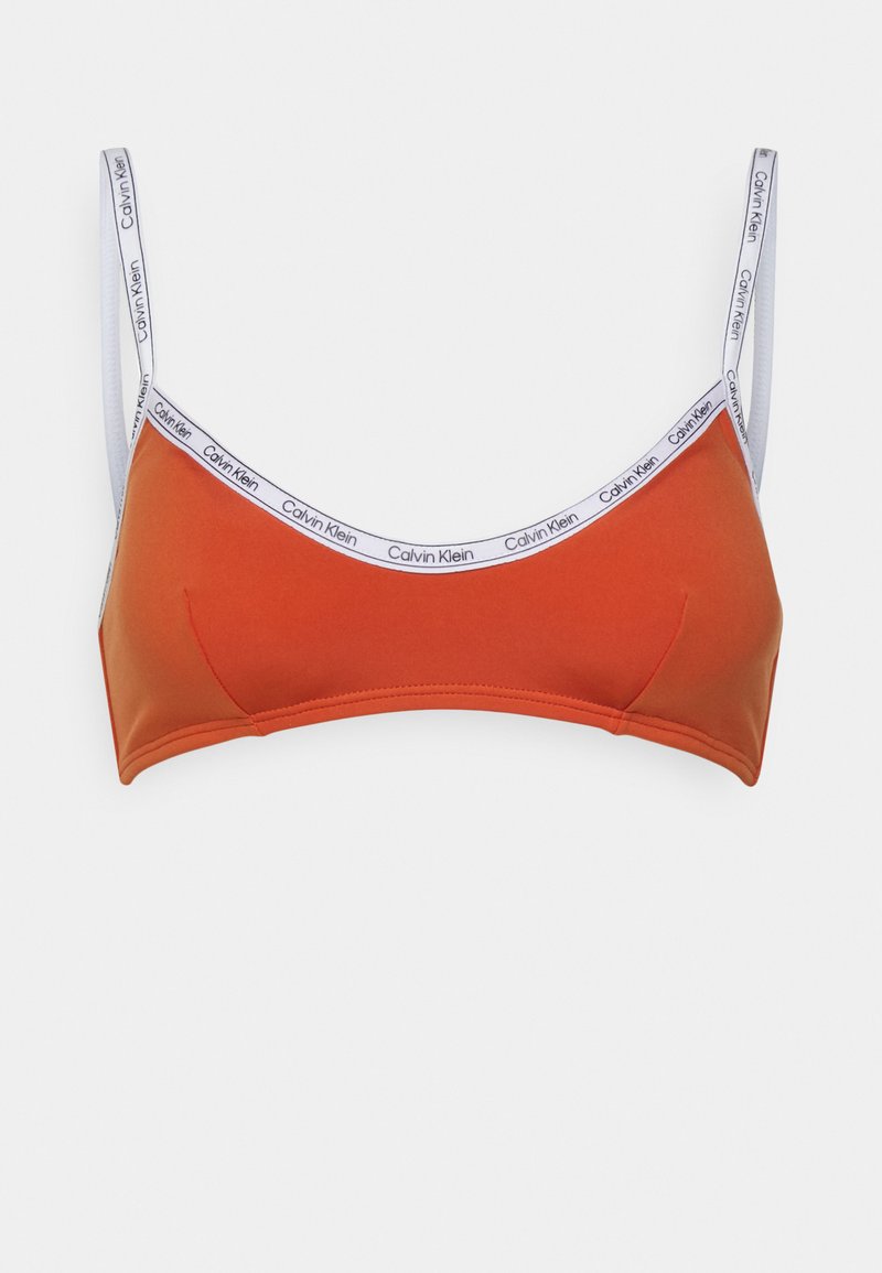 Bralette laranja com alças finas e uma faixa branca com o logótipo "Calvin Klein". Tecido suave com um design sem costuras.
