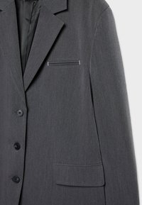 Veste de costume pour homme gris foncé avec revers cranté, trois boutons noirs et deux poches avant, vue de face côté droit.