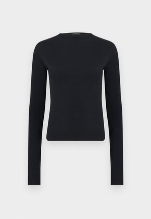 Bluză crop top neagră, cu mâneci lungi, croită strâns, cu gât rotund, realizată din țesătură cu nervuri, prezentată pe un fundal simplu, de culoare gri deschis.