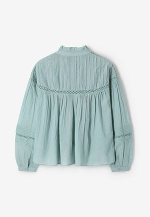 Lichtblauwe blouse met lange mouwen, hoge hals, verticale plooien, kantafwerking over de rug en mouwen, en met knopen afgesloten manchetten.