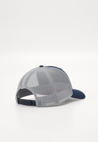 Marineblå caps med teksturert mesh-bak og stiv skjerm. Har en justerbar stropp og subtile søm detaljer på skjermen.