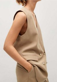 Beige ärmelloses Top mit V-Ausschnitt, doppelter Knopfleiste, zwei Vorderfächern und taillierter Silhouette. Glatter, leichter Stoff.