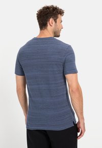 Blåstribet kortærmet t-shirt i et blødt, struktureret stof. Har rund halsudskæring og sideslids i kanten for nem bevægelse.