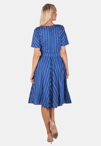 Blaues Kleid mit weißen vertikalen Streifen, kurzen Ärmeln, taillierten Oberteil, ausgestellt Rock und cinchiger Taille. Glattes Material, knielanges Design.