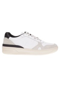 Zapatilla blanca con acentos de ante gris, talón de cuero negro y suela blanca texturizada. Presenta una puntera redondeada y un diseño de cordones.
