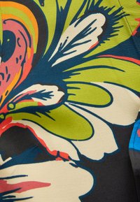 Tissu floral multicolore présentant de grandes feuilles vertes, des nuances de rose et des contours noirs audacieux. Texture lisse avec un design vif.